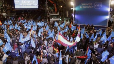 Simpatizantes en las inmediaciones en la sede del Partido Popular, esta tarde en la madrileña calle Génova, para celebrar la posible victoria electoral de los populares en las elecciones generales