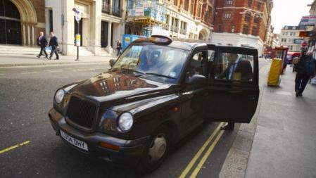 Un cliente entrando en un 'black cab', el clásico taxi londinense