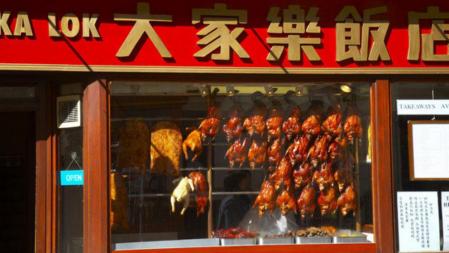 Ejemplares de pato laqueado colgados en un escaparate de un restaurante de Chinatown