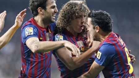 Los jugadores del F. C. Barcelona, Cesc Fábregas, Carles Puyol y Xavi Hernández, celebran el primer gol del equipo blaugrana