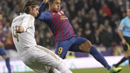El defensa del Real Madrid Sergio Ramos trata de superar al chileno Alexis Sánchez