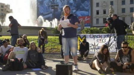Un joven participa, micrófono en mano, en lo que se ha denominado 'Foro de los Pueblos', un espacio en la Plaza de Catalunya de Barcelona, donde los miembros del movimiento 15M debaten sobre las preocupaciones de la ciudadanía