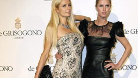 La diseñadora estadounidense Nicky Hilton y su hermana Paris Hilton posan a su llegada a la fiesta de De Grisogono