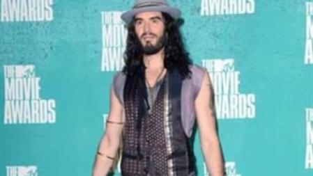Russell Brand prefirió una camiseta lila y pitillos metalizados con botas cowboy
