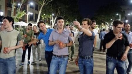 Paseo nocturno. Jóvenes turistas de distintas nacionalidades pasean la borrachera y consumen alcohol en las calles de Ciutat Vella, seguidos muy de cerca por lateros