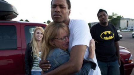 La madre de una chica que se encontraba en el cine de Denver abraza a uno de los amigos de su hija