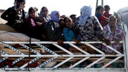 Un grupo de refugiados sirios, en su mayoría mujeres y niños, atraviesan la frontera con Turquía