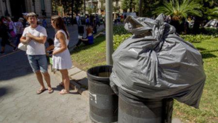 Una bolsa de basura colocada indebidamente en una papelera, una imagen que no es una anécdota en el paseo de Gràcia a pleno día