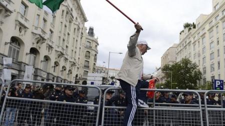 Un manifestante se encarama a la valla policial ante el Congreso durante el 25-S