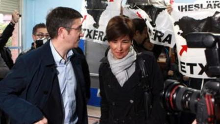 Un grupo de personas ha recibido hoy con carteles en apoyo de los presos de ETA al lehendakari, Patxi López y su esposa, Begoña Gil, en el colegio electoral de Bilbao donde han depositado su voto