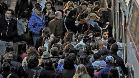 Varios pasajeros se apretujan al ingresar a un tren en la estación de Atocha, en Madrid, en el día de la huelga general