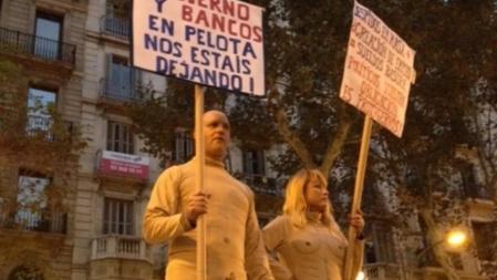 Manifestantes en Barcelona portan pancartas contra los recortes y el papel de los bancos y los políticos en la crisis económica