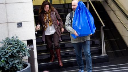 Mossos de paisano sacan una bolsa con material confiscado de las dependencias de Urbanismo del ayuntamiento de Sabadell