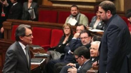 El líder de CiU, Artur Mas, mira al presidente de ERC, Oriol Junqueras, durante la primera jornada del pleno de dos días que permitirá a Mas ser investido de nuevo presidente de la Generalitat de Catalunya.