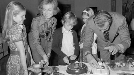 1976 Madrid.- El Príncipe Felipe corta la tarta de su octavo cumpleaños ante la mirada de la Reina Sofía y las Infantas Elena y Cristina, mientras el Rey Juan Carlos monta uno de los juguetes que le han regalado. La Familia Real celebró una fiesta familiar en el Palacio de La Zarzuela