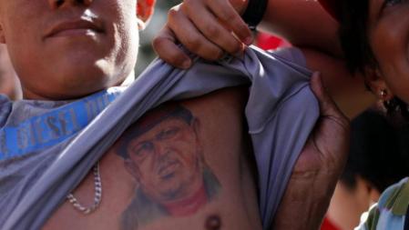 Un hombre muestra un tatuaje del presidente venezolano Hugo Chávez en los alrededores del Palacio de Miraflores en Caracas (Venezuela) para participar en la concentración convocada por el Partido Socialista Unido de Venezuela (PSUV) en la jornada en que el mandatario debía asumir el cargo para el periodo 2013-2019