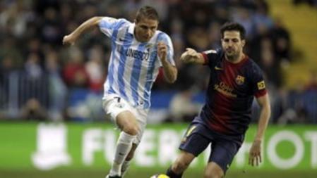 El centrocampista del Málaga Joaquín Sánchez lucha el balón ante el centrocampista del Barcelona Francesc Fábregas