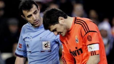 El portero del Real Madrid Iker Casillas habla con el colegiado Miguel Angel Pérez Lasa tras lesionarse en su partido ante el Valencia