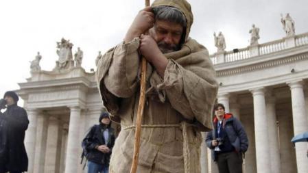 Un peregrino reza arrodillado en la Plaza de San Pedro del Vaticano, en la Ciudad del Vaticano, antes del inicio del cónclave