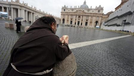 Un fraile lee la Biblia en la Plaza de San Pedro del Vaticano durante el segundo día del cónclave