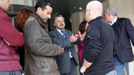 Un empleado de banca de explicaciones a clientes frente a una oficina de Nicosia.