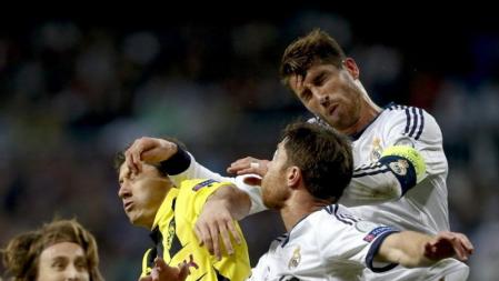 Sergio Ramos pone el codo en el cuello de Robert Lewandowski mientras Xabi Alonso también lucha para cazar el balón