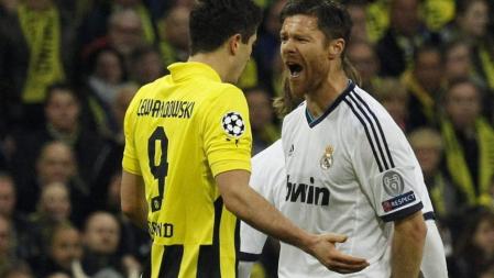 El centrocampista del Real Madrid Xabi Alonso ante el delantero polaco del Borussia Dortmund Robert Lewandowski