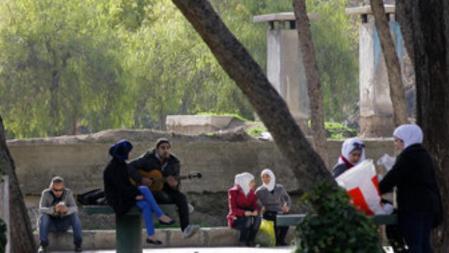 Un joven toca la guitarra junto a una chica y cerca de otras personas que pasan un rato en un parque de la ciudad el pasado mes de febrero, en una escena de relajamiento que hace olvidar la guerra civil en que está inmerso el país