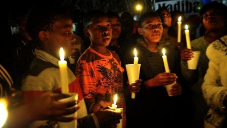 Niños rezan por Nelson Mandela frente al hospital de Pretoria donde está ingresado