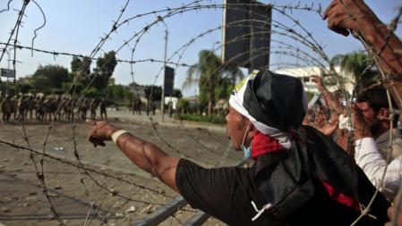 Manifestantes a favor de Mohamed Morsi protestan ante una alambrada frente al cuartel de la Guardia Republicana de El Cairo