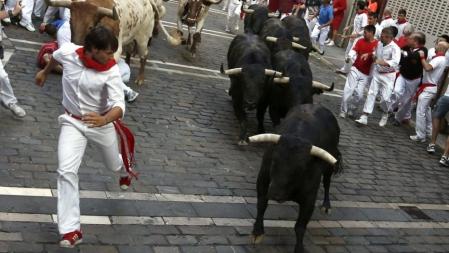 Los mozos corren, por la calle Estafeta, delante de los toros de la ganadería madrileña de Victoriano del Río