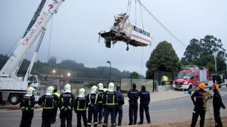 Uno de los vagones accidentados es retirado por una grúa