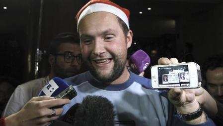 El canario Jesus Lorente muestra en su móvil una foto del décimo con el número 79.712, con el que ha sido agraciado con el segundo premio en el Sorteo Extraordinario de la Lotería de Navidad, que seguía en directo en el Teatro Real