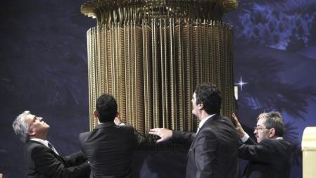 Varias personas comprueban el paraguas con las liras que recogen las bolas ordenadas, antes del inicio del Sorteo Extraordinario de Navidad que se celebra hoy en el escenario del Teatro Real