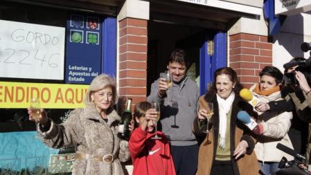 La lotera Maria Luisa (i) celebra con una familia agraciada con el Gordo de Navidad, el 62.246, a la entrada su administración, número 8 de Leganés, que ha repartido hoy 360 millones de euros de ese primer premio, dotado con cuatro millones de euros por serie (400.000 euros por décimo) en el sorteo extraordinario de la Lotería de Navidad. EFE/Zipi