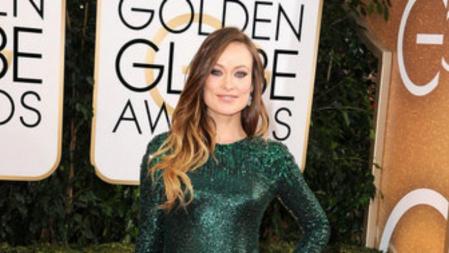 Olivia Wilde, embarazada, muy bella con un vestido brillante verde esmeralda de Gucci sobre la alfombra roja de los Globos de Oro