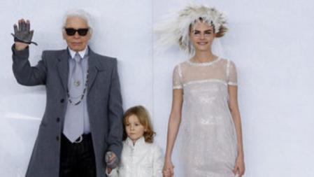 El diseñador Karl Lagerfeld junto a Hudson Kroenig y la modelo Cara Delevingne al final del desfile de Chanel, que ha presentado sus propuestas para primavera-verano 2014 en la Alta Costura de París