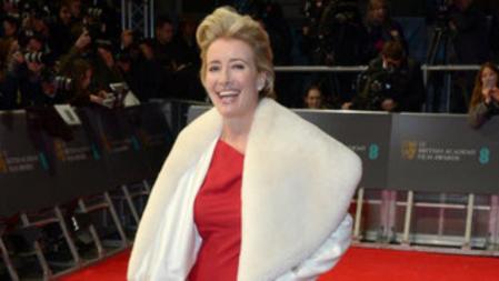Emma Thompson con un vestido rojo y un abrigo de piel blanco en los Bafta