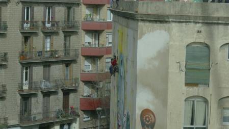 Dos integrantes del CSO La Carboneria, colgados en la fachada para frenar el desalojo policial del edificio