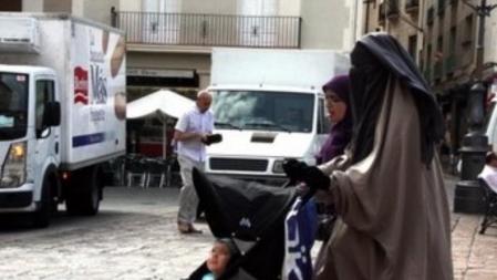 Una mujer vestida con niqab, paseando por la plaza Mercadal de Reus, en julio de 2013