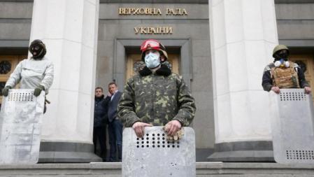 Los manifestantes han tomado varios edificios gubernamentales ante el vacío de poder que impera en Kiev | En la imagen, algunos opositores controlan la entrada y la salida de los diputados en la Rada Suprema
