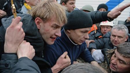 Un hombre sospechoso de ser un policía antidisturbios es detenido por manifestantes opositores en Kíev