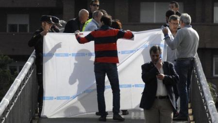 Agentes de la policía cubren el cuerpo de la presidenta de la Diputación de León, Isabel Carrasco, muerta a tiros en plena a calle