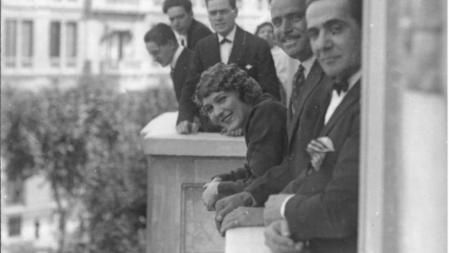 Mary Pickford y Douglas Fairbancks saludan desde una de las ventanas del Hotel Ritz durante su visita a Barcelona la primera quincena del mes de junio de 1925