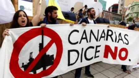 Varias personas protestan con pancartas contra las prospecciones petrolíferas autorizadas por el Ministerio de Medio Ambiente en aguas de Canarias