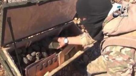 Un miliciano del estado Islámico muestra un cargamento de armas supuestamente lanzado por Estados Unidos a los kurdos de Kobaneque ha caído en sus líneas