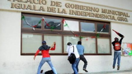 Un grupo de encapuchados rompe los cristales del ayuntamiento de Iguala, México, tras una protesta por los 43 estudiantes desaparecidos