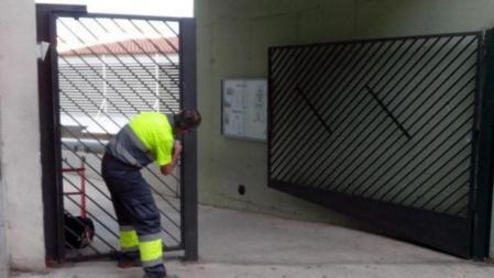 Un operario retira la silicona que impedía abrir la puerta del colegio Carmel, en la calle Llobregós de Barcelona