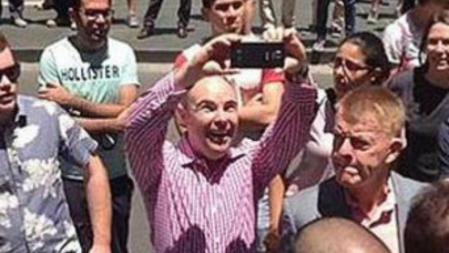 Captura de pantalla de un 'tuit' que muestra a una persona tomándose una foto cerca de la cafetería donde se ha producido un secuestro en Sydney.