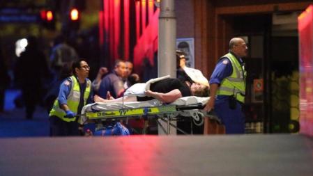 Uno de los rehenes es evacuado herido del café de Sydney.